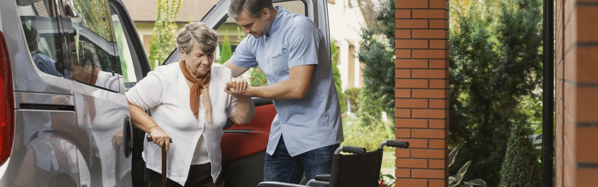 Caregiver accompanying senior citizen safely during vehicle transition - Hero Slide 1